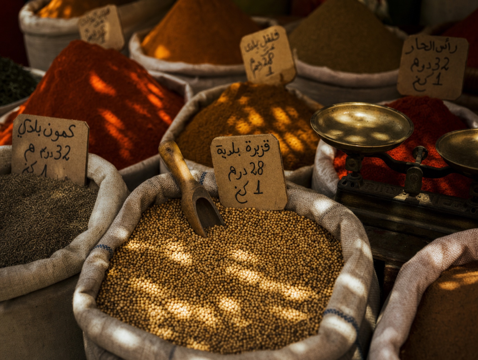 Marokkanischer Gewürzhändler schöpft Koriandersamen im Souk von Marrakesh