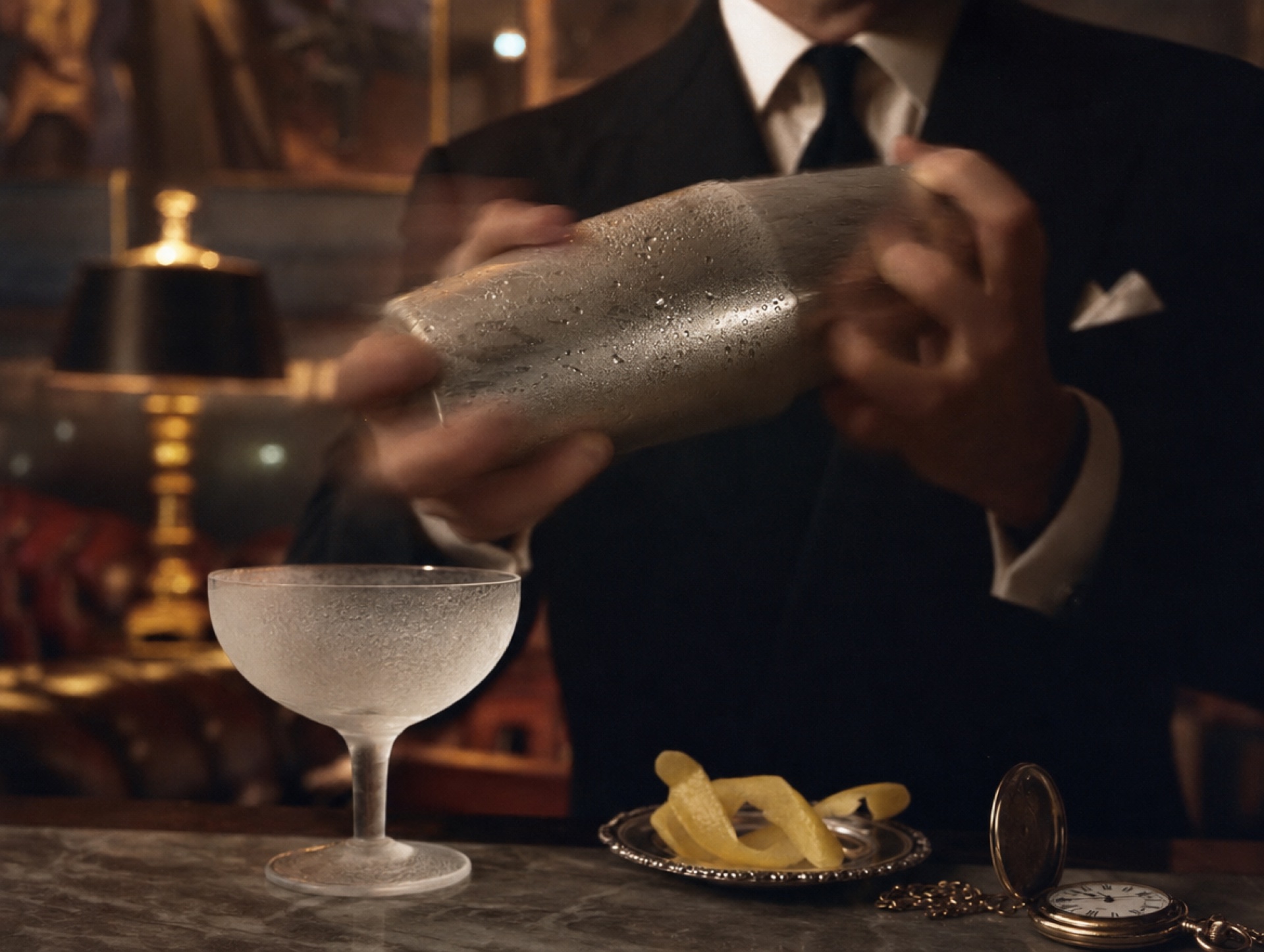 Versilberter Cocktail-Shaker in Bewegung mit Frostperlen