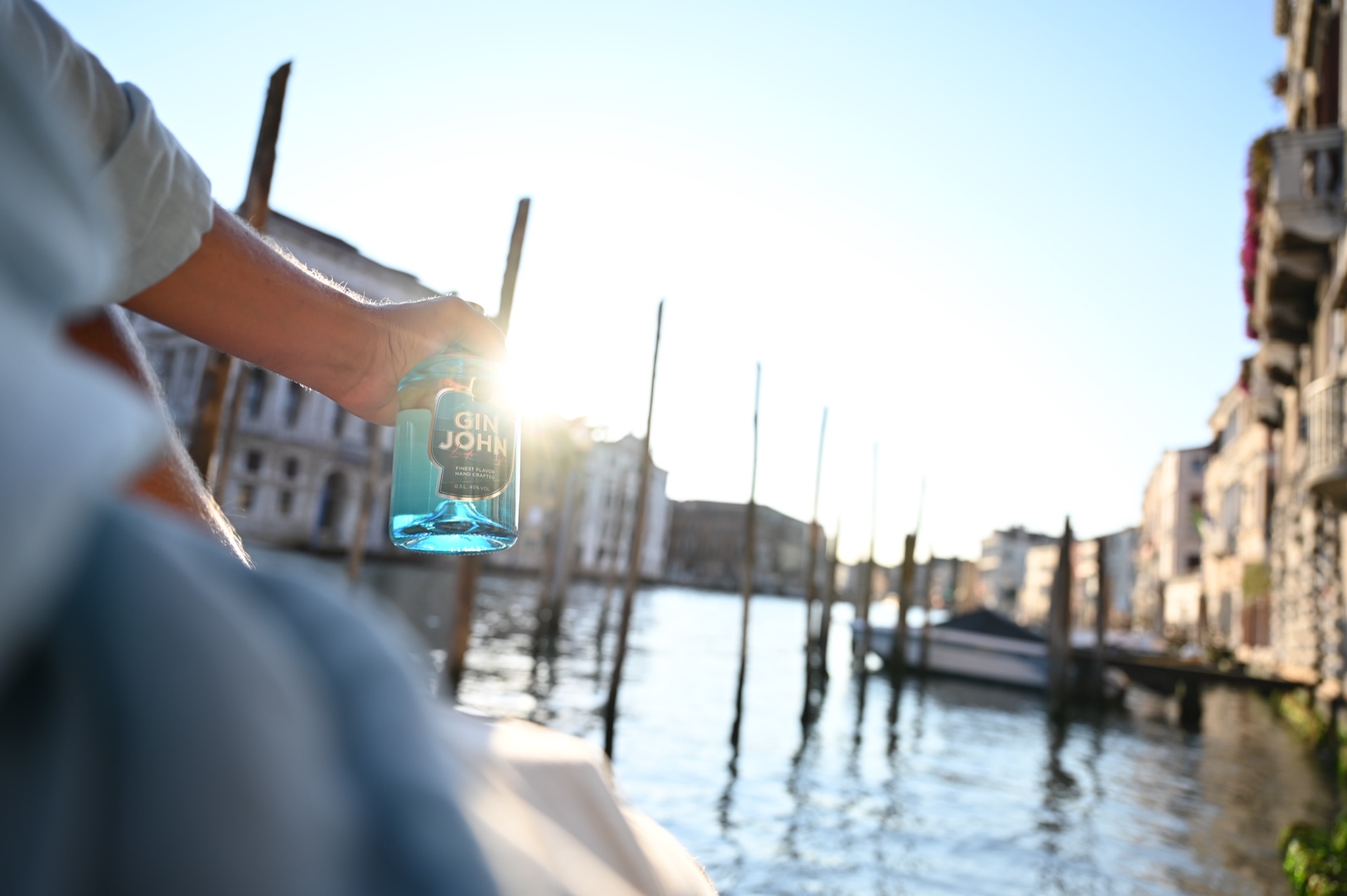 Gin John in Venedig zwischen Holzpfählen am Wasser