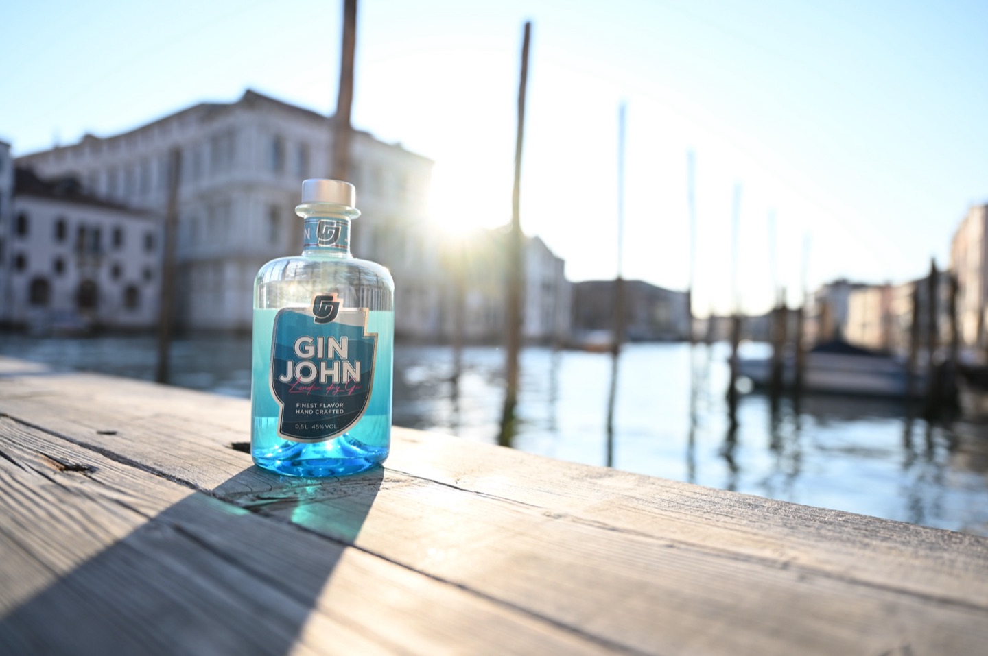 Gin John auf Holzsteg am Canal Grande mit Sonne durchs Glas